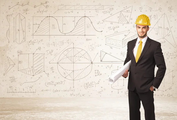 Handsome engineer calculating with hand drawn background — Stock Photo, Image