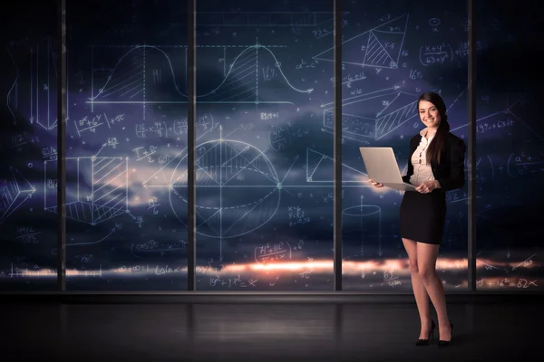 Businesswoman holding laptop in office room with graph charts on — Stock Photo, Image