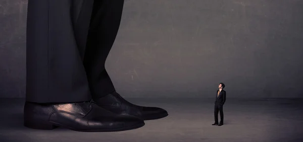 Pernas enormes com pequeno empresário em pé na frente conceito — Fotografia de Stock