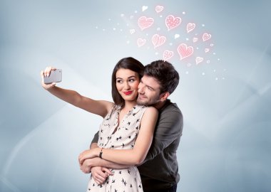 Aşık çift kırmızı kalple selfie çekiyor.