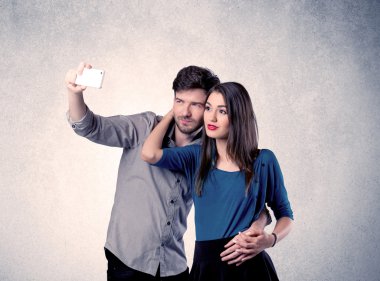 Mutlu çift temiz duvarlı selfie çekiyor.