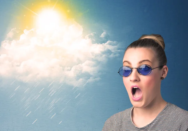 Young person looking with sunglasses at clouds and sun — Stock Photo, Image