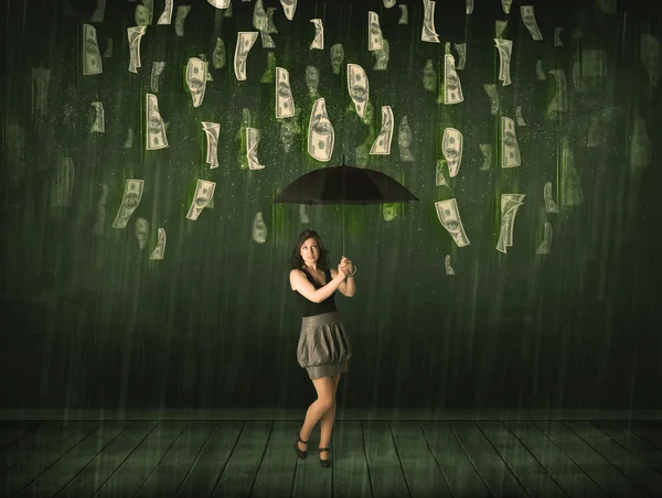 Businesswoman standing with umbrella in dollar bill rain concept — Stock Photo, Image