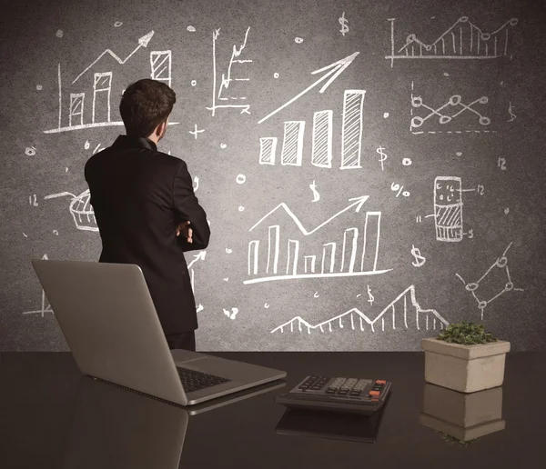 Businessman drawing sales charts on wall — Stock Photo, Image