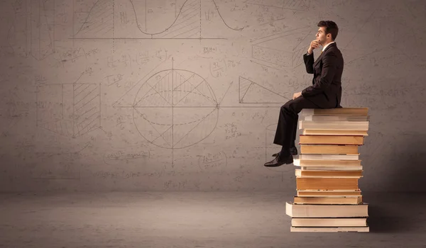 Hombre de negocios sentado en los libros — Foto de Stock