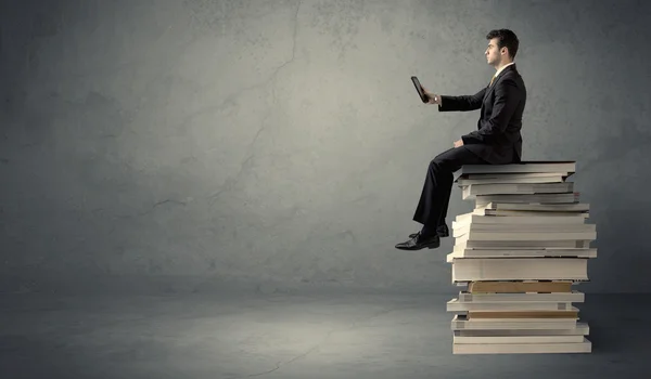 Étudiant assis sur une pile de livres — Photo