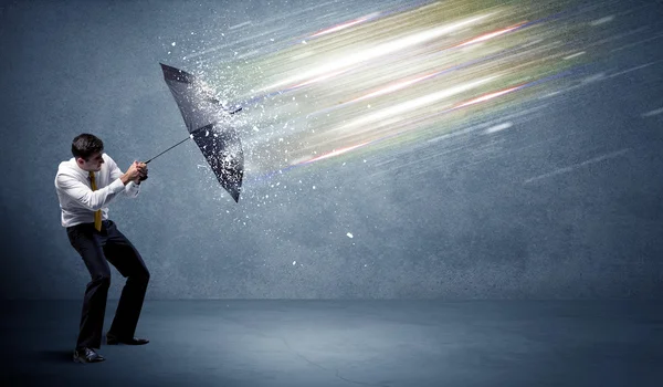 Business man defending light beams with umbrella concept — Stock Photo, Image