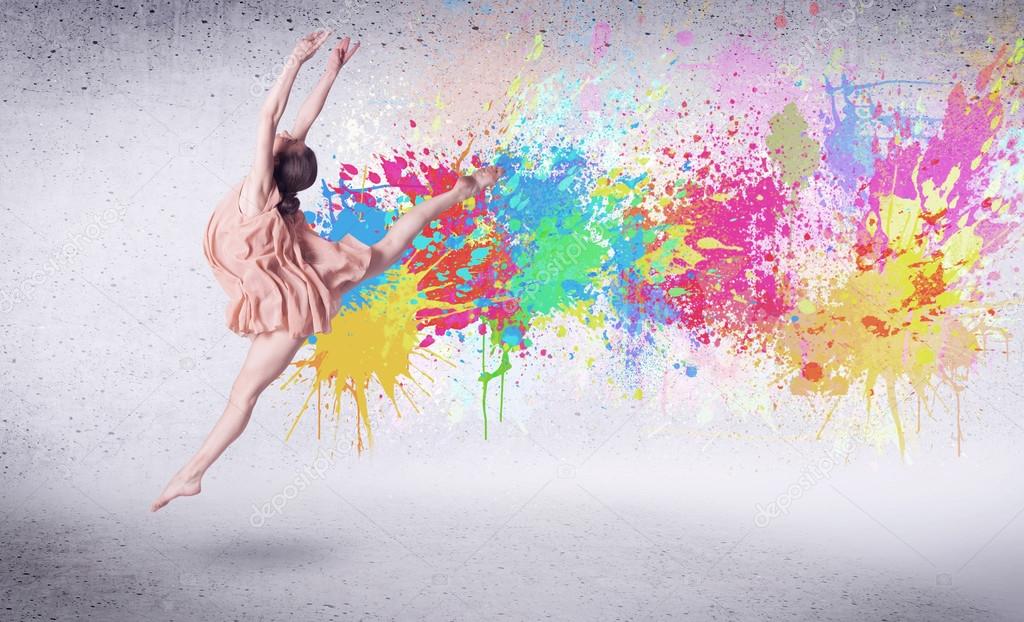 Modern street dancer jumping with colorful paint splashes