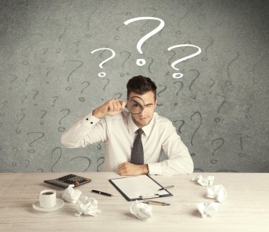 İş adamı soru işaretiyle masada.