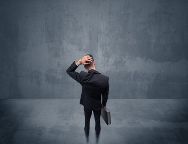 Şehir duvarının önünde duran iş adamı