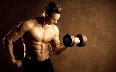 Kas formundaki vücut geliştirici sporcu ağırlık kaldırıyor 