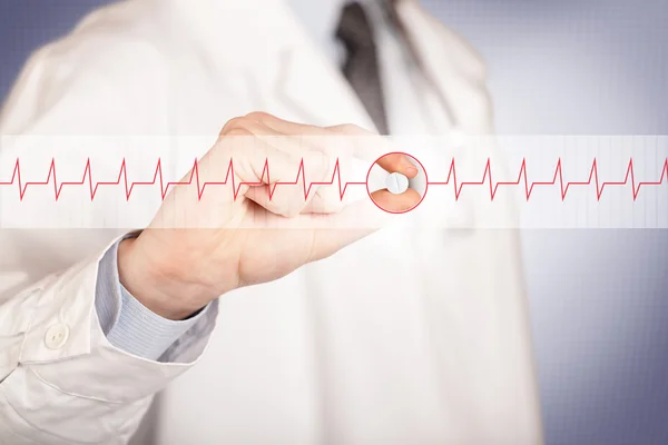 En läkare som håller i ett hjärtpiller — Stockfoto