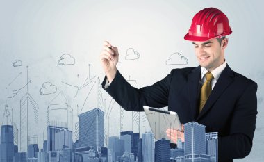 Genç işçi şehir manzarası çiziyor.