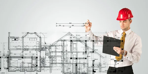 Genç bir mimar ev planı çiziyor.