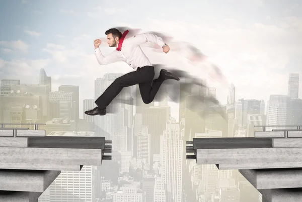 Energetic business man jumping over a bridge with gap — Stock Photo, Image