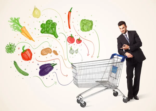 Businessman pushing a shopping cart with vegetables — Stock Photo, Image