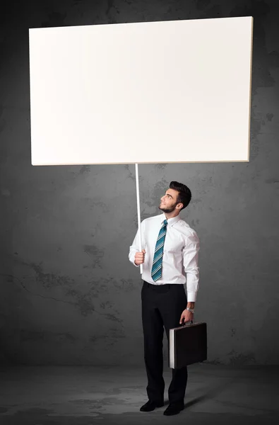 Young businessman with a blank whiteboard — Stock Photo, Image