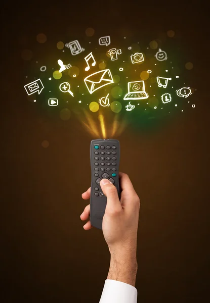 Hand with remote control and social media icons — Stock Photo, Image