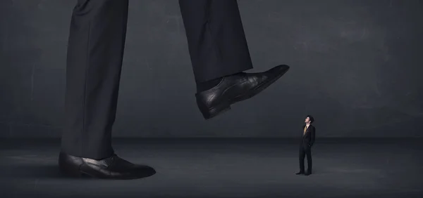 Giant person stepping on a little businessman concept — Stock Photo, Image