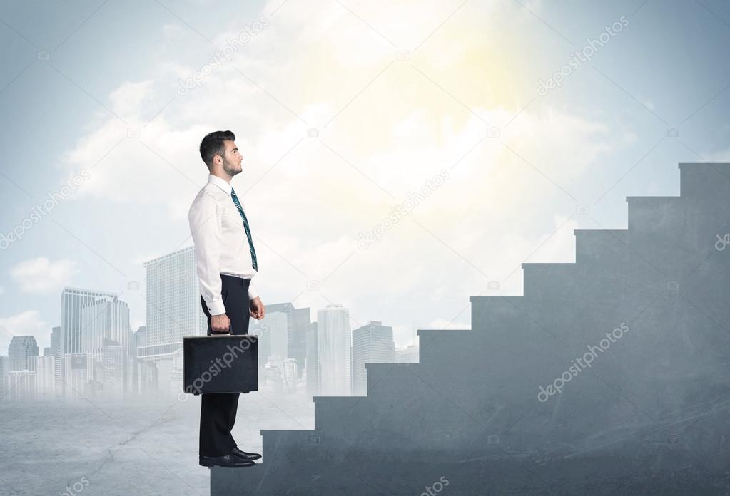 Businessman climbing up a concrete staircase concept