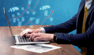 Satıcı dizüstü bilgisayarla grafikle çalışıyor.