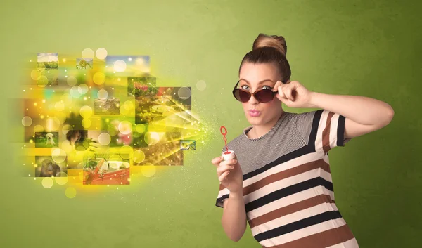 Cute girl blowing colourful glowing memory picture concept — Stock Photo, Image