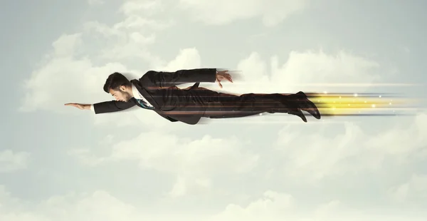 Glad affärsman flyger snabbt på himlen mellan molnen — Stockfoto