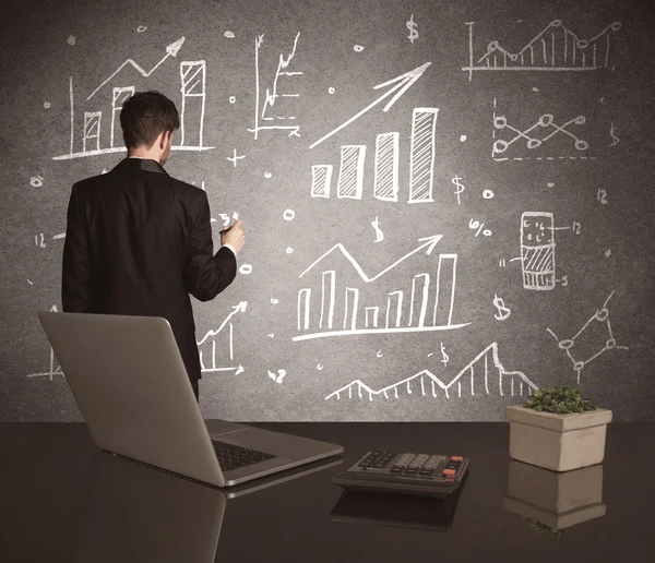 Businessman drawing sales charts on wall — Stock Photo, Image