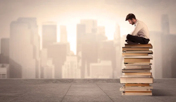 Hombre sentado en los libros de la ciudad — Foto de Stock