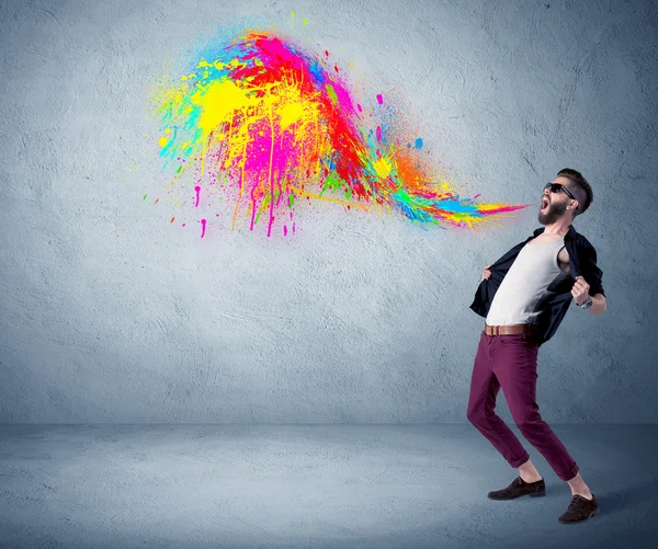 Hipster kerel schreeuwen kleurrijke verf op de muur — Stockfoto