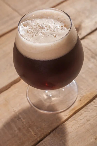 Cerveja escura em madeira — Fotografia de Stock