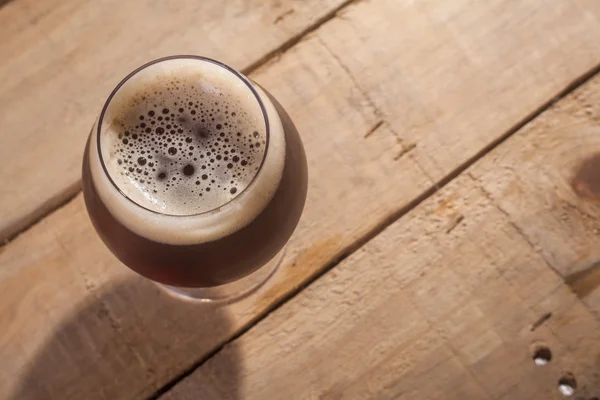 Cerveja escura em madeira — Fotografia de Stock