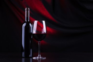 Kırmızı şarap kadehi ve şişe.