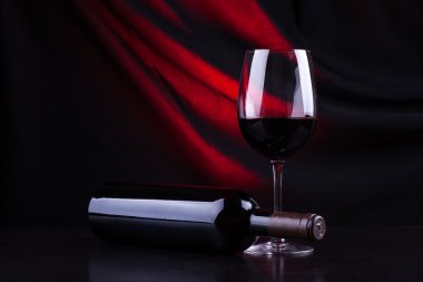 Kırmızı şarap kadehi ve şişe.