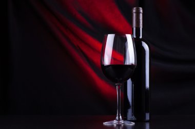 Kırmızı şarap kadehi ve şişe.