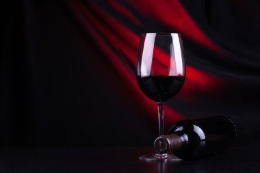 Kırmızı şarap kadehi ve şişe.