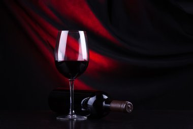 Kırmızı şarap kadehi ve şişe.