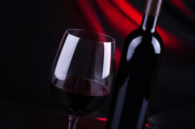 Kırmızı şarap kadehi ve şişe.