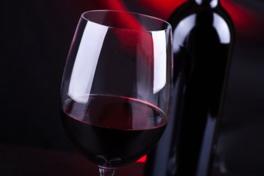 Kırmızı şarap kadehi ve şişe.