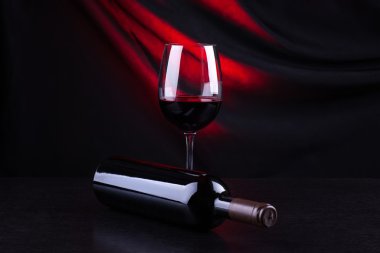 Kırmızı şarap kadehi ve şişe.