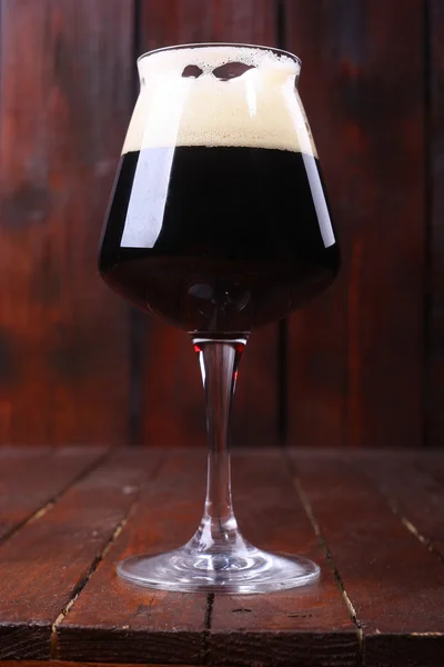 Темное пиво на дереве — стоковое фото