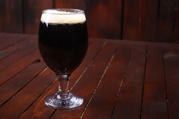 Темное пиво на дереве — стоковое фото