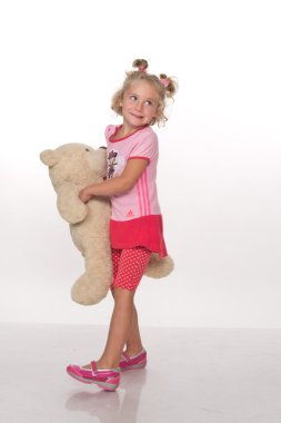 Küçük kız oyuncak ayıyla oynuyor.