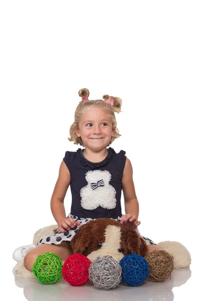 Little girl sitting on dog toy — Stock Photo, Image