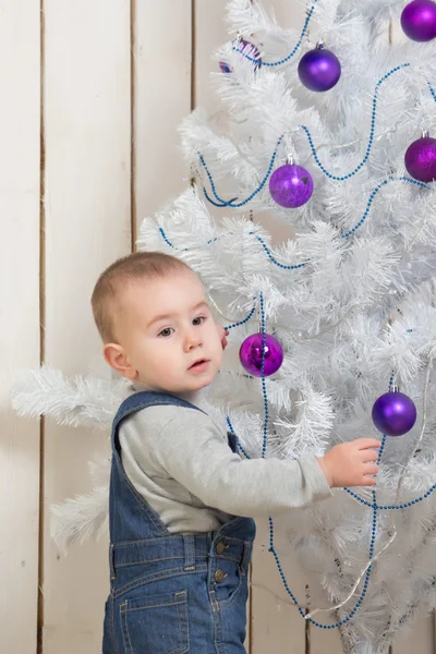 Baby boy under Christmas fir tree — Stock Photo, Image