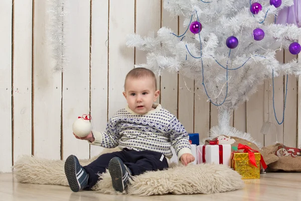 Baby boy under Christmas fir tree — Stock Photo, Image