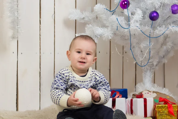 Baby boy under Christmas fir tree — Stock Photo, Image