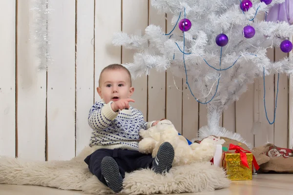 Baby boy under Christmas fir tree — Stock Photo, Image