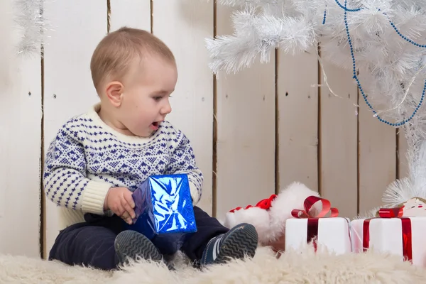 Baby boy under Christmas fir tree — Stock Photo, Image