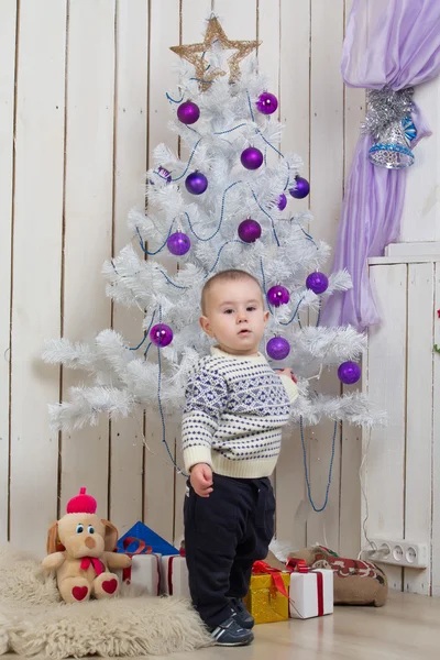 Baby boy under Christmas fir tree — Stock Photo, Image